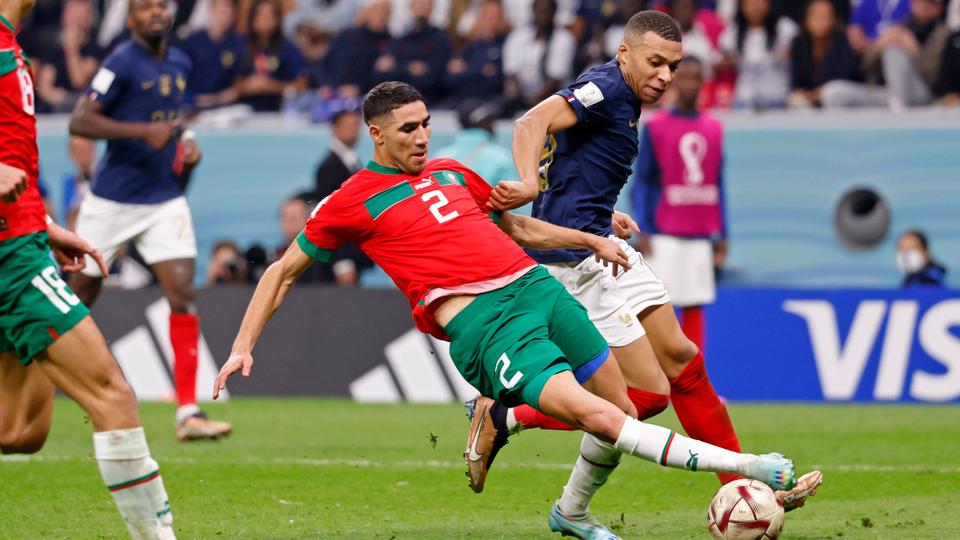 Morocco defender Achraf Hakimi (2) knocks the ball away from France forward Kylian Mbappe (10) during the second half of a semifinal match during the 2022 World Cup at Al Bayt Stadium.
