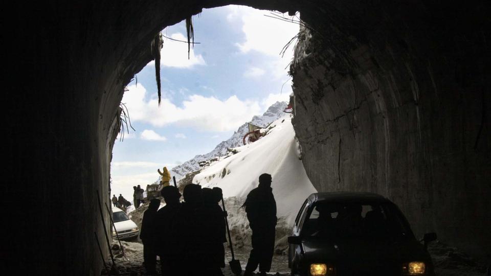 In this file photo, Afghan workers clear a portion of the opening of the tunnel to widen its access in Salang as cars start to negotiate its muddy entrance.