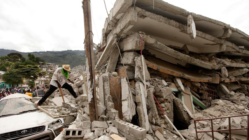 In this file photo dated January 14, 2010, people work to free trapped victims from the rubble of a collapsed building after an earthquake in Port-au-Prince, Haiti.