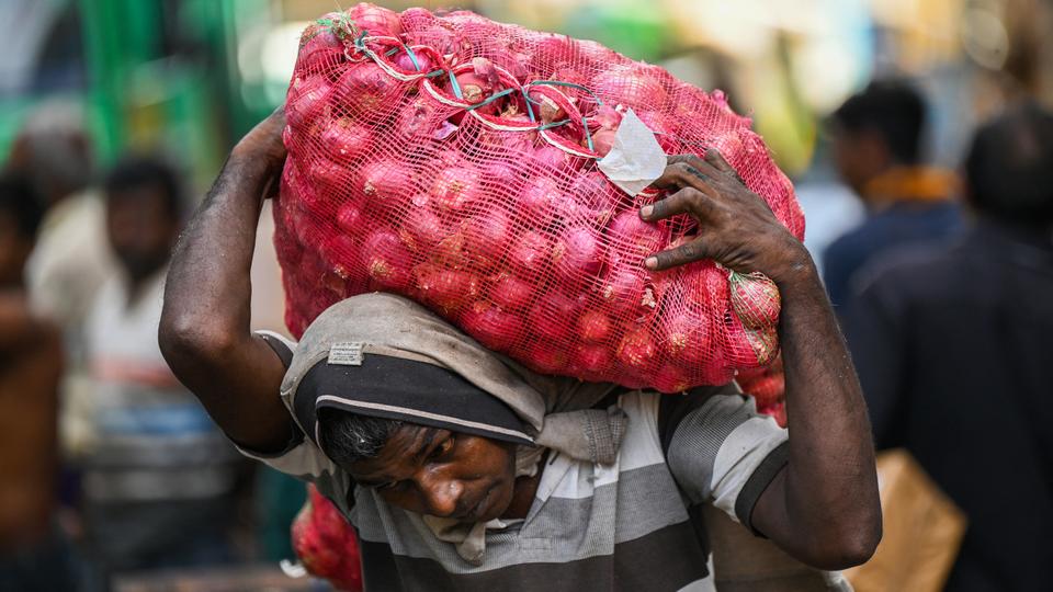 A labourer carries a sack of onions at a market in Colombo on March 20, 2023.