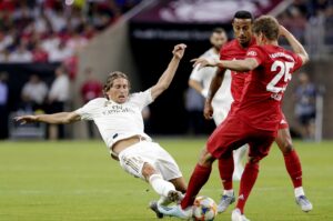Real Madrid's Luka Modric (L) slides as he goes for the ball against Bayern Munich players during the first half of an International Champions Cup match, Houston, U.S., July 20, 2019. (AP Photo)