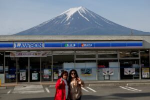 Chinese tourists pose for photos of Mount Fuji appearing over a convenience store in Fujikawaguchiko town, Yamanashi Prefecture, Japan, May 21, 2024. (Reuters Photo)